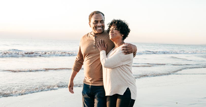 A happy senior couple walking on the beach