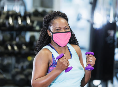 A woman exercising safely at the gym using her fitness center discounts from Optima Health.