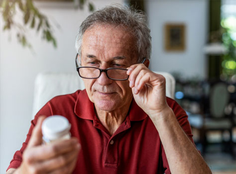 A senior man  managing his prescription medications.