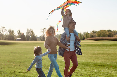 A happy family going kiting on a sunny day.