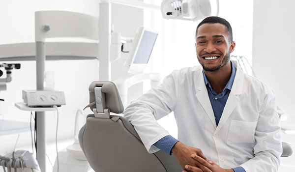 Smiling male dentist sitting in dentist chair